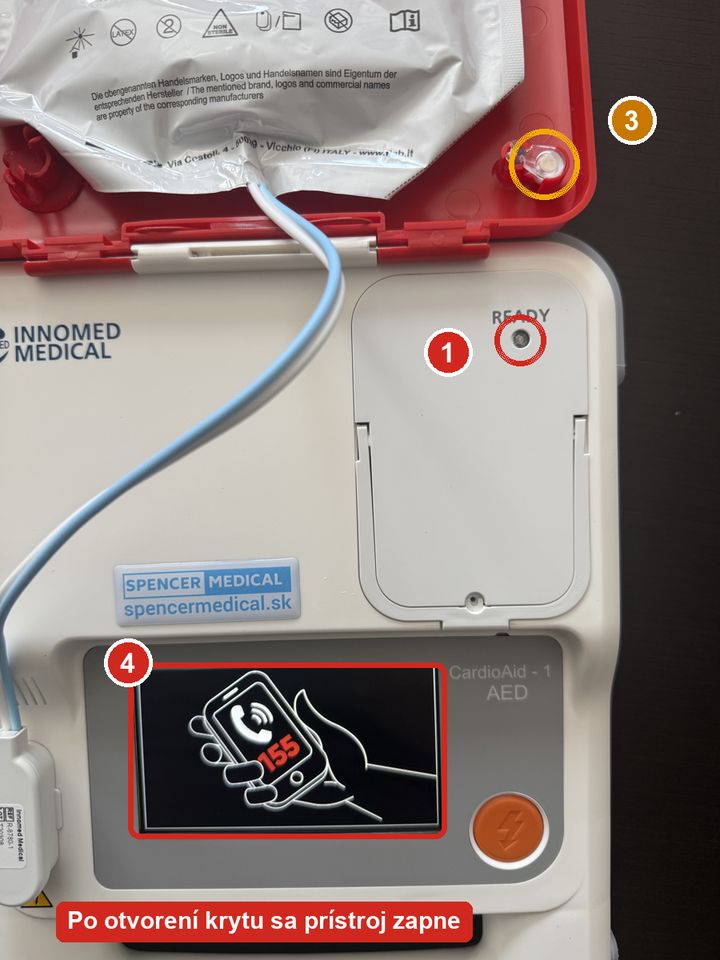 CardioAid-1 s otvoreným krytom: 1 kontrolka READY na batérii, 3 svetlovod v kryte, 4 zapnutý displej